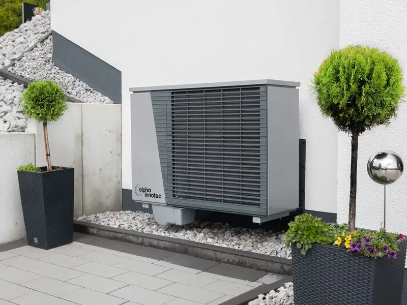 Newly installed heat pump beside a brick house