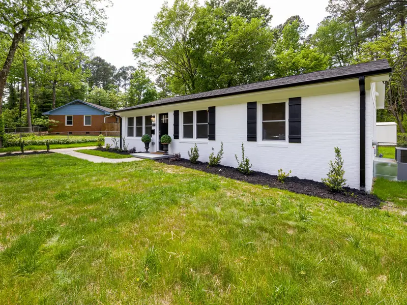 Brick ranch home under pine trees in North Raleigh